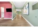 Spacious hallway featuring wood floors, modern lighting, and stylish wall decor at 20 Scotland Dr, Youngsville, NC 27596