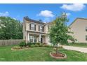 Charming two-story home featuring a manicured lawn and inviting landscaping with trees and flowering plants at 2018 Morehead Hill Ct, Durham, NC 27703