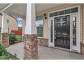Inviting front porch with stone-clad pillars and a stylish black front door with decorative accents at 2018 Morehead Hill Ct, Durham, NC 27703