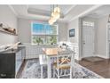 Bright dining room with large window, tray ceiling, and a decorative rug under the wood table at 208 Cecelia Ct, Cary, NC 27519