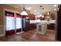 Beautiful kitchen features stainless steel appliances, a wine rack island, and hardwood floors at 2109 Taramar Ln, Zebulon, NC 27597