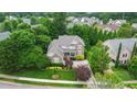 Aerial view of a brick two story home surrounded by mature trees and lush green lawns at 220 Cole Valley Dr, Cary, NC 27513