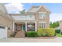Inviting brick home featuring a cozy front porch, manicured landscaping, and a bright blue front door at 220 Cole Valley Dr, Cary, NC 27513