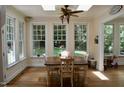 Sun-filled dining room with large windows, hardwood floors, a modern ceiling fan, and comfortable seating at 2216 Countrywood North Rd, Raleigh, NC 27615