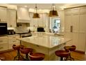 Bright kitchen with marble countertops, island with seating, stainless steel appliances, and custom cabinets at 2216 Countrywood North Rd, Raleigh, NC 27615