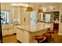 Bright kitchen with marble countertops, island with seating, stainless steel appliances, and custom cabinets at 2216 Countrywood North Rd, Raleigh, NC 27615