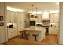 Bright kitchen with white cabinets, marble countertops, pendant lighting, and stainless steel appliances at 2216 Countrywood North Rd, Raleigh, NC 27615