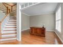 Spacious living room with hardwood floors, staircase, and natural light at 225 Norwalk St, Holly Springs, NC 27540
