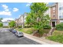 Street view of townhouses featuring brick accents, small gardens, and convenient parking at 229 Michigan Ave, Cary, NC 27519