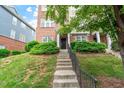 Inviting townhouse entrance with concrete steps, black door, and manicured shrubs at 229 Michigan Ave, Cary, NC 27519