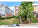 Charming townhouse with brick and blue siding, surrounded by lush greenery and trees at 229 Michigan Ave, Cary, NC 27519