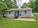 Charming front exterior showcasing a light gray exterior, a blue front door and manicured landscaping at 2409 Derby Dr, Raleigh, NC 27610