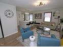 Inviting living room with modern decor, neutral walls, and wood-look floors that opens up to the kitchen at 2409 Derby Dr, Raleigh, NC 27610