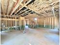 Large, unfinished basement with exposed wooden beams, concrete flooring, framed walls, and a staircase at 243 Steel Springs Ln # 25, Angier, NC 27501