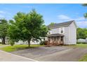 A two-story home with a covered front porch and ramp access, with shade trees at 2527 Ossipee Front St, Elon, NC 27244
