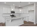 Modern kitchen features white cabinets, granite countertops, stainless steel appliances, and an island at 3916 Well Fleet Dr, Fuquay Varina, NC 27526