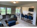 Open-concept living area with a comfortable gray sofa and a kitchen island with bar seating at 4097 Cordiality Church Rd, Nashville, NC 27856
