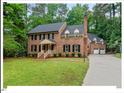 Beautiful brick home featuring an attached garage, basketball hoop, and surrounded by lush greenery at 45 Birnham Ln, Durham, NC 27707