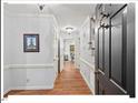 Bright and spacious hallway with hardwood floors and classic wainscoting detail at 45 Birnham Ln, Durham, NC 27707