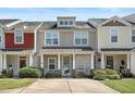 Attractive townhome featuring a welcoming porch, manicured shrubs, and classic facade under a bright, sunny sky at 4807 Landover Charge Ln, Raleigh, NC 27616