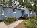 Beautiful blue home surrounded by nature, showcasing its unique design and well-maintained landscaping at 507 Holtz Ln, Cary, NC 27511