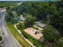 Aerial image of a colorful neighborhood playground with swings, slides, and climbing structures, surrounded by trees at 519 W Raleigh St, Siler City, NC 27344
