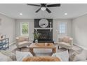 Inviting living room featuring a painted brick fireplace, modern furniture, and bright natural light at 5804 Heathill Ct, Raleigh, NC 27603