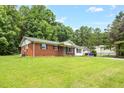 Classic single-story house featuring brick and white accents, a cozy front yard, and mature trees at 5805 Craig Rd, Durham, NC 27712