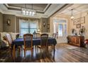 Formal dining room features hardwood floors, tray ceilings, and elegant chandelier lighting at 67 Marshlane Way, Clayton, NC 27527