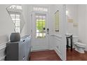 Foyer with stylish console storage, a half bath, and glass pane front door at 740 Treviso Ln, Apex, NC 27502