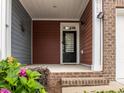 Inviting front porch with brick steps and colorful flower accents at 740 Treviso Ln, Apex, NC 27502