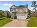 Charming two-story home featuring solar panels, a well-maintained lawn, and a two-car garage at 76 Haywood St, Spring Lake, NC 28390