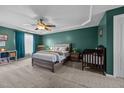 Spacious main bedroom featuring a tray ceiling, ceiling fan, and neutral carpet at 76 Haywood St, Spring Lake, NC 28390