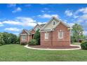 Well-maintained brick home featuring pristine landscaping, showcasing curb appeal on a sunny day at 7800 Twin Pines Way, Fuquay Varina, NC 27526
