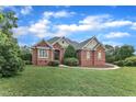 Stately brick residence, perfectly manicured lawn, and welcoming entrance, all under a bright sky at 7800 Twin Pines Way, Fuquay Varina, NC 27526