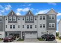 Modern two-story townhome featuring a two car garage, neutral gray tones and professional landscaping at 816 Lilyquist Way, Wake Forest, NC 27587