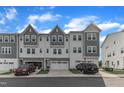 Beautifully appointed townhome with a two car garage, gray facade, and well-manicured lawn at 816 Lilyquist Way, Wake Forest, NC 27587