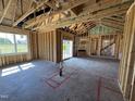 Framing stage of an open-concept living room with natural light and sliding glass doors to the outdoors at 82 Laramie Ln, Selma, NC 27576