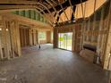 An open-concept living room in the framing stage, showing the framework for a fireplace and sliding glass doors at 82 Laramie Ln, Selma, NC 27576
