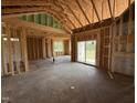 Unfinished living room featuring vaulted ceilings and sliding glass door leading to the backyard at 82 Laramie Ln, Selma, NC 27576