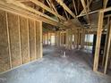 Unfinished living room shows framed construction, exposed beams, high ceilings and framed walls at 82 Laramie Ln, Selma, NC 27576