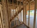 Wood frame stairway leading to the second floor, with natural light streaming in from the garage at 82 Laramie Ln, Selma, NC 27576