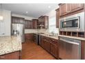 Modern kitchen showcases stainless steel appliances and dark cabinetry with granite countertops at 826 Downfield Ln, Fuquay Varina, NC 27526