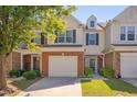 Inviting townhome exterior with a brick facade, attached garage, and lush green lawn at 8404 Saltwood Pl, Raleigh, NC 27617