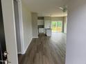 Open concept living with wood floors, view of the kitchen, and access to the outdoor deck at 90 Brookhaven Dr, Spring Hope, NC 27882