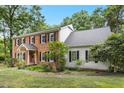Side view of a two-story home with brick and vinyl siding, showcasing its architectural design at 9509 Greenfield Dr, Raleigh, NC 27615