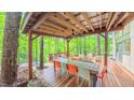 Expansive covered back deck featuring outdoor dining and lounge areas, perfect for entertaining amidst the beautiful scenery at 1 Davie Ln, Chapel Hill, NC 27514
