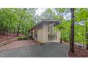 Stylish exterior with walls of glass, complementing the lush forest surroundings, inviting natural light and scenic views at 1 Davie Ln, Chapel Hill, NC 27514