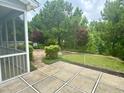 Tranquil backyard featuring a screened porch, manicured lawn, and lush greenery at 1004 Bridlemine Dr, Fuquay Varina, NC 27526