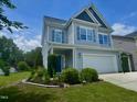 Two-story home with a well-manicured front yard featuring colorful flower beds and shrubs at 1004 Bridlemine Dr, Fuquay Varina, NC 27526